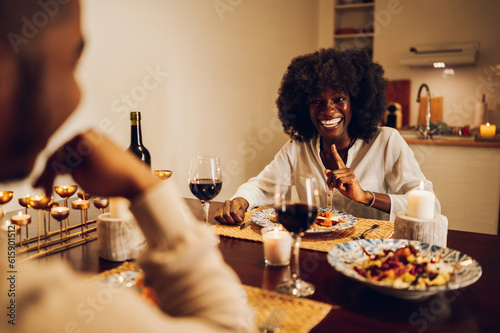 African american couple having romantic dinner date and drinking wine at home