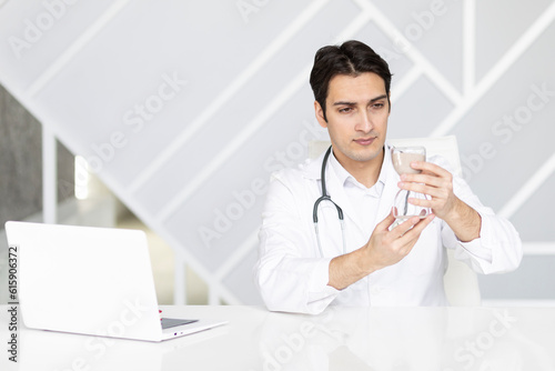 Close-up photo of physician holding hourglass. Time and health concept 