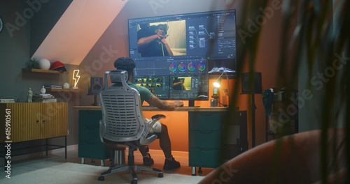 Bild auf Leinwand African American colorist edits action movie, makes color correction in professional software on multi-monitor computer and big digital screen, works at home office