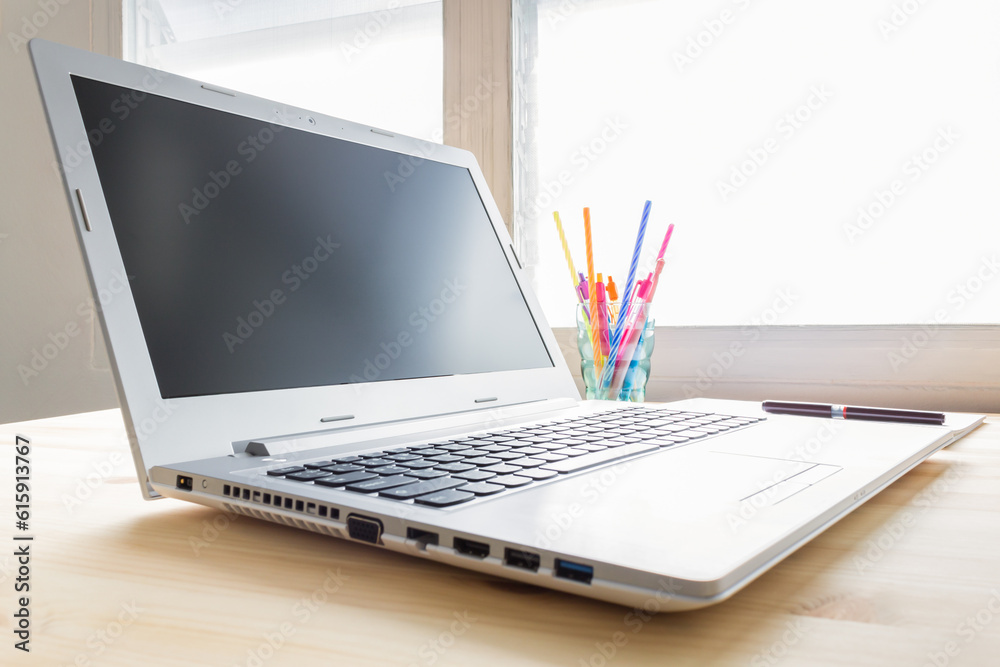Laptop and notebook and pen and glass on wood table in old office with soft evening light Laptop and notebook and pen and glass on wood table in old office with soft evening light