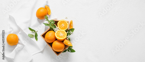 Boxes with fresh oranges and blooming branches on white background with space for text