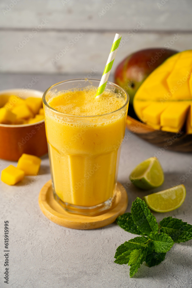 Fototapeta premium Mango smoothie in a glass with fresh mango, mint and lime.