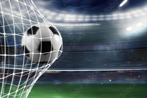 Ball scores a goal on the net in a football match photo