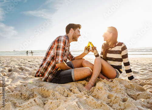 Young couple at the beach having fun, laughing and drinking beer © Designpics