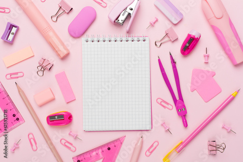 Pink school stationery with notebook on color backgroung, top view