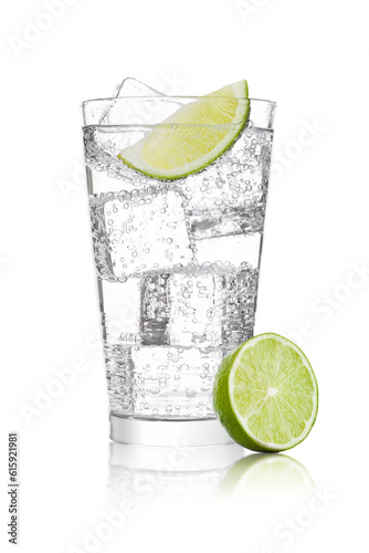 Glass of sparkling water soda drink lemonade with ice and lime slice on white background