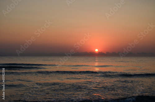 Sunrise on a Spanish beach in Oliva with waves and view to the ocean