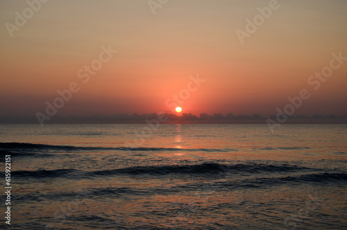 Sunrise on a Spanish beach in Oliva with waves and view to the ocean