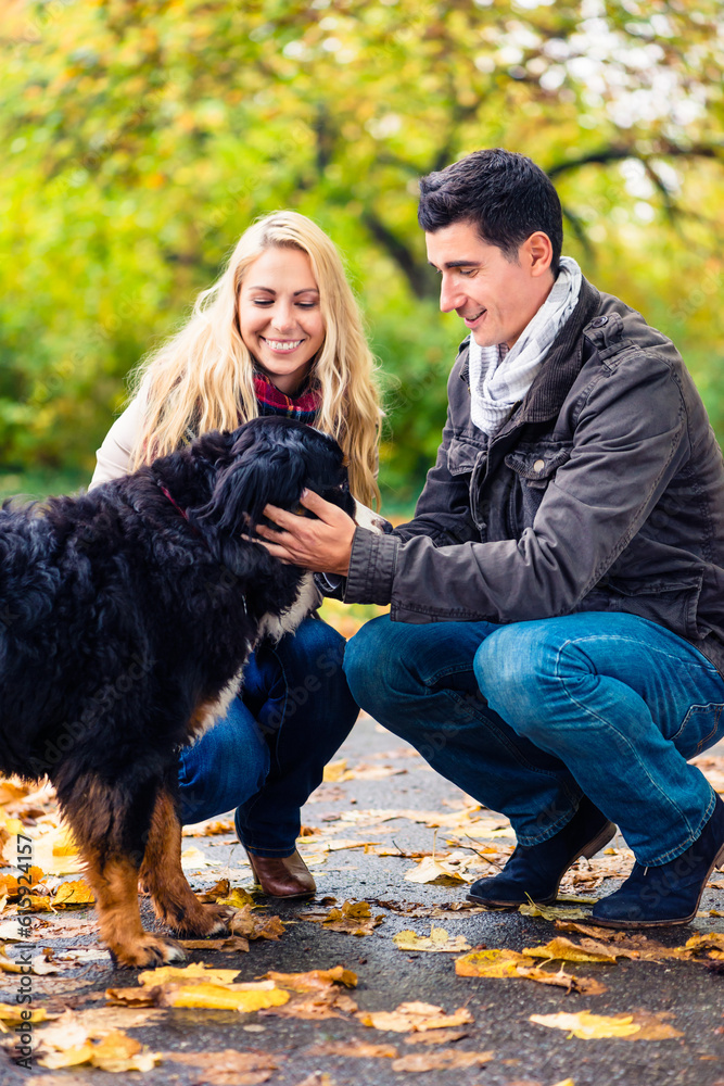 Couple with dog enjoying autumn or fall in nature