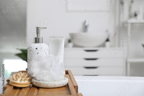 Fototapeta Naklejka Na Ścianę i Meble -  Shower sponge, massage brush and soap dispenser on wooden board, closeup