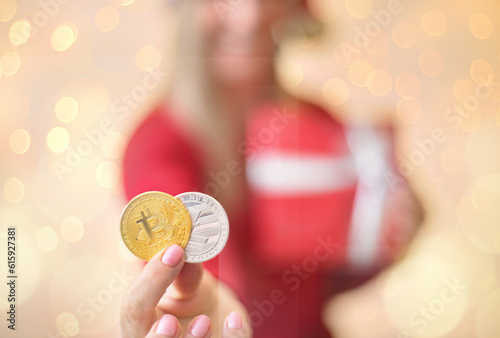 Sydney, Australia - December 17, 2017;  Using cryptocurrency to buy gifts and presents at Christmas.  A woman is holding a bitcoin and a litecoin in her hand and smiling