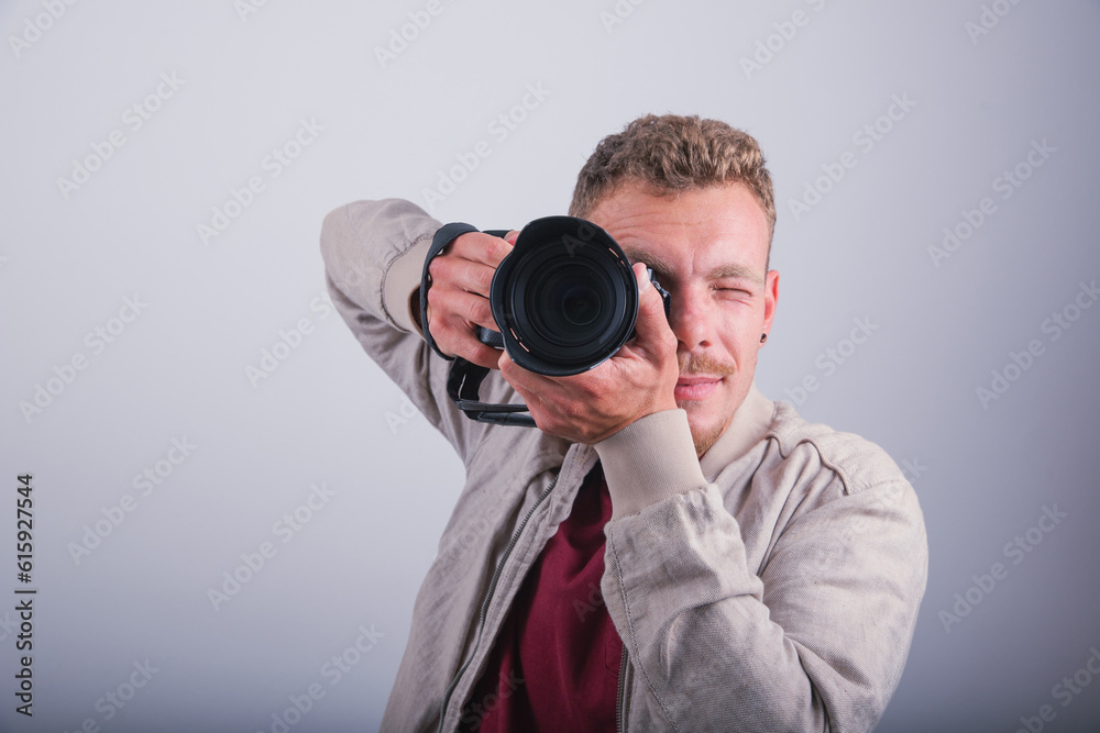 A photographer takes a photograph with his DSLR, studio shot with a white background A photographer takes a photograph with his DSLR, studio shot with a white background