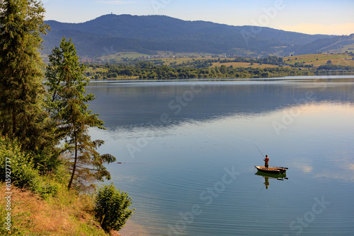 Man fishing from his boat at Czorsztyn lake in Spisz region of Poland