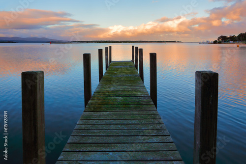 Old timber jetty with green mossy planks in the sunset