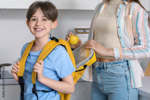 Mother putting school lunch...