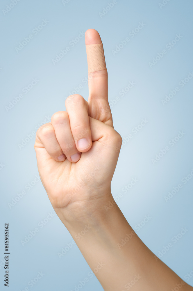 Female index finger with an adhesive bandage Female index finger with an adhesive bandage