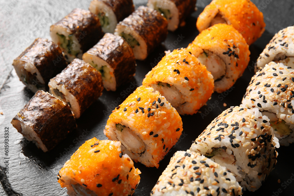 Tasty sushi rolls on dark background, closeup view Tasty sushi rolls on dark background, closeup view