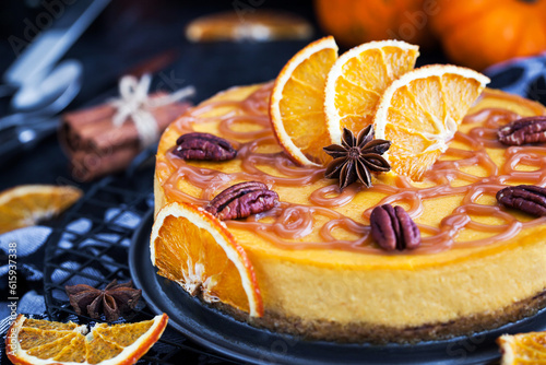 Delicious pumpkin and orange cheesecake decorated with caramel sauce and pecan