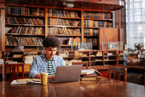 Graduate student writing doctoral thesis in university library.
