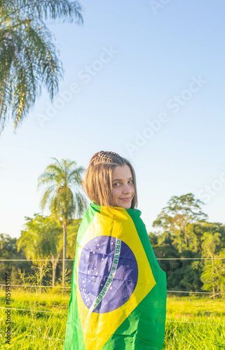 Brazilian holding Brazil. Young smiling brazilian woman smiling at camera with brazil flag