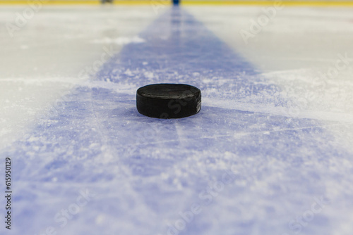 detail blue line with puck on ice hockey rink