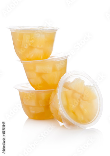 Single cups with pineapples in fruit jelly on white background