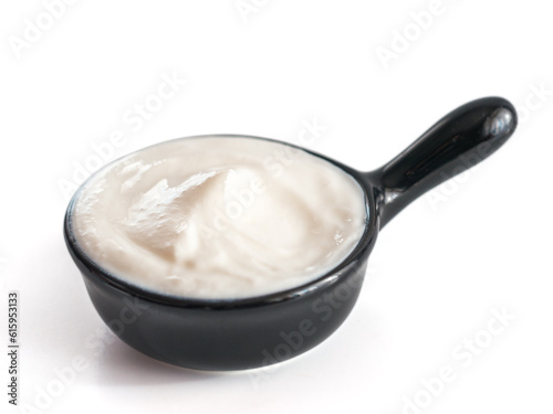 Beautiful greek yogurt or sour cream in black bowl, isolated on white background with clipping path. Copy space for text