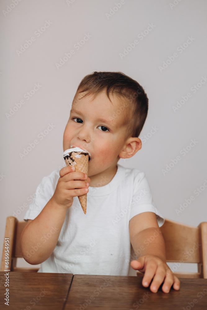 boy eating ice cream in a waffle cup at home in the kitchen
boy eating ice cream in a waffle cup at home in the kitchen