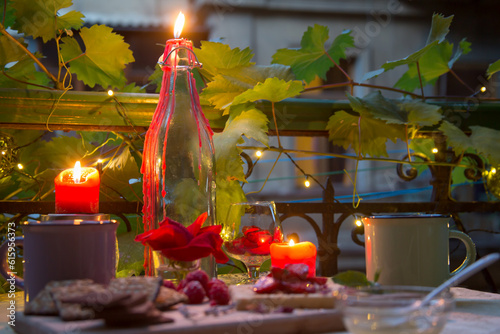 Candles on romantic table with sweets at late evening