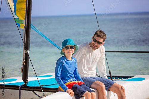 family of two, father and son, enjoying sailing together at hobie cat catamaran, active healthy lifestyle concept