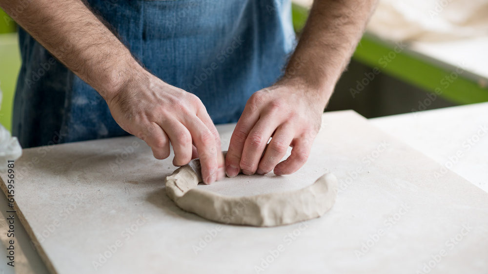 Ceramist Dressed in an Apron Working with Raw Clay in the Bright Ceramic Workshop.