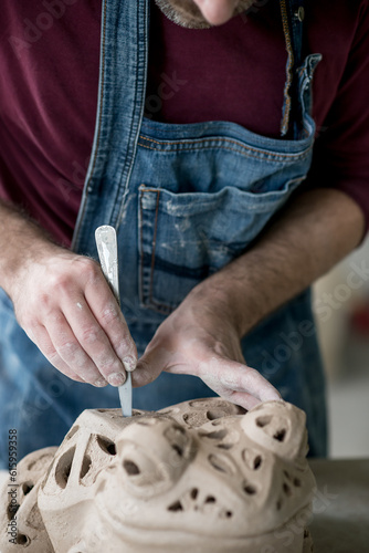 Ceramist Dressed in an Apron Sculpting Statue from Raw Clay in the Bright Ceramic Workshop.