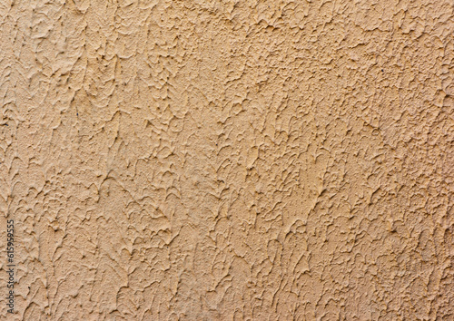 fragment of beige wall with decorative plaster of waves, full frame