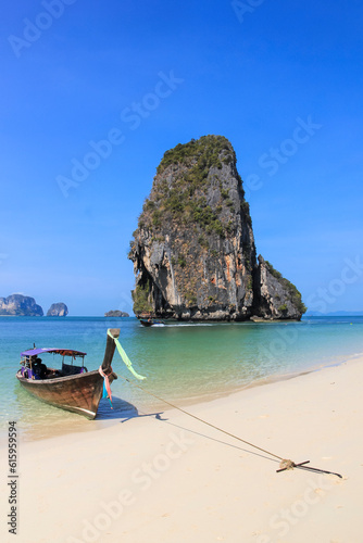 Fototapeta Naklejka Na Ścianę i Meble -  Traditional Wooden Longtail Boat anchored on Railay Beach in Krabi Province Southern Thailand, Longtail Boats are used as water taxis between the beaches and islands of krabi a popular tourism destina