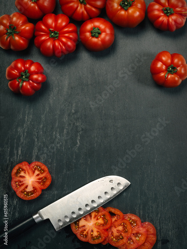 Fotografía Photo of a table top with Marmande tomatoes, a knife, and slices with copy space in the middle