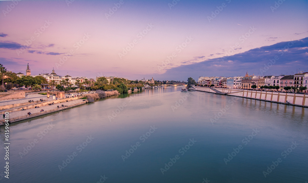 Blue Hour vew of Cathedral, Giralda Tower and the Guadalquivir river in Sevilla, Spain. View from Triana Bridge..