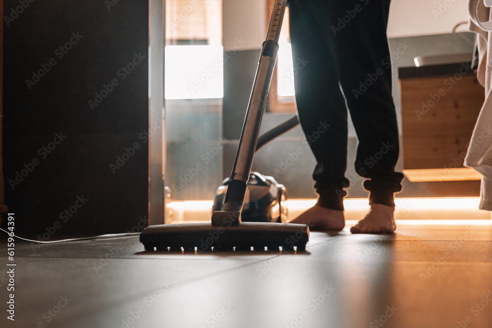 Fototapeta premium Bathroom cleaning.Man cleaning the room.Cleanliness and house cleaning concept. Cleaning equipment. Vacuum cleaner in the bathroom. The man is vacuuming in a dark bathroom with lighting.