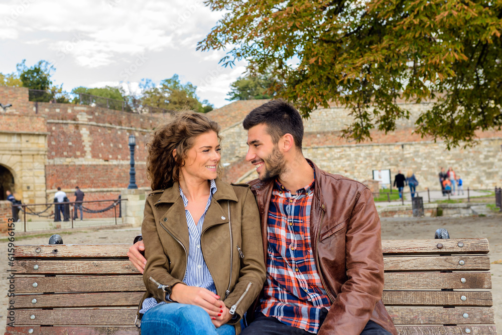 Attractive couple in love enjoying moments of happiness on the bench in city park Attractive couple in love enjoying moments of happiness on the bench in city park