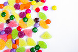 Scattered colored candy on a limited white background