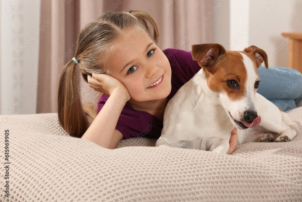Cute girl with her dog on bed indoors. Adorable pet Cute girl with her dog on bed indoors. Adorable pet