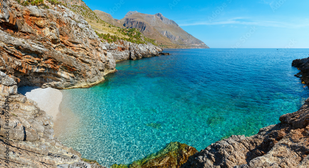 Paradise sea bay with azure water and beach. View from coastline trail of Zingaro Nature Reserve Park, between San Vito lo Capo and Scopello, Trapani province, Sicily, Italy. Two shots stitch panorama