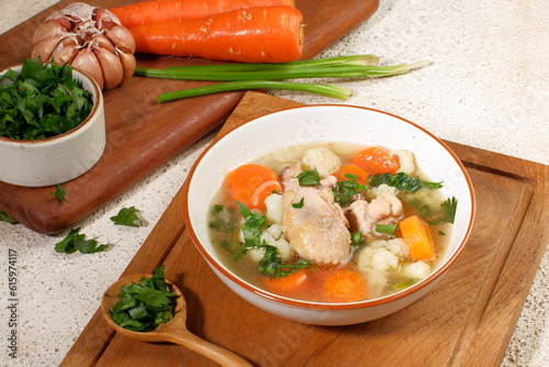 Homemade chicken soup with vegetables in a white bowl.Healthy warm comfortable food. photo