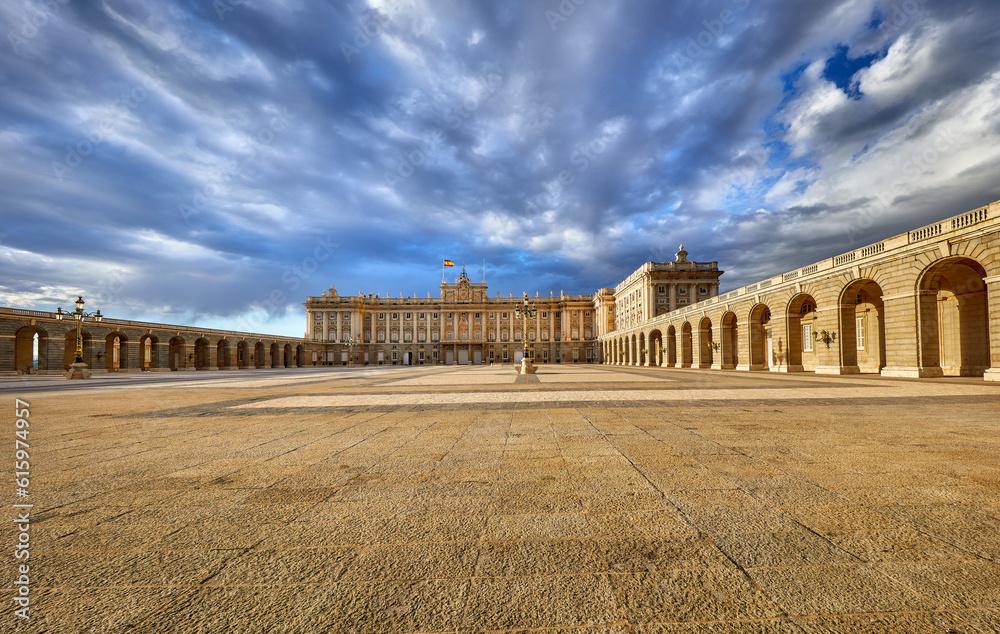 Royal palace in Madrid, Spain. Plaza de la Armeria, inner yard in front of building. Sunset with dramatic sky.