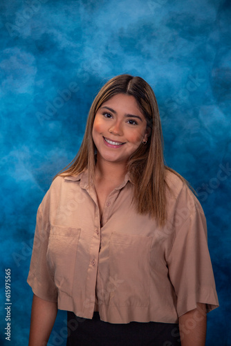 Pretty young woman in beige clothes with black posing in studio against green background