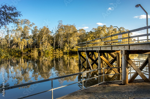 Beautiful scenery at Moama Wharf in Echuca VIC Australia. Trees in the sunset and water reflection on Murray River in the background.