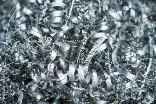 Steel scrap materials recycling. Aluminum chip waste after machining metal parts on a cnc lathe. Closeup twisted spiral steel shavings. Small roughness sharpness,