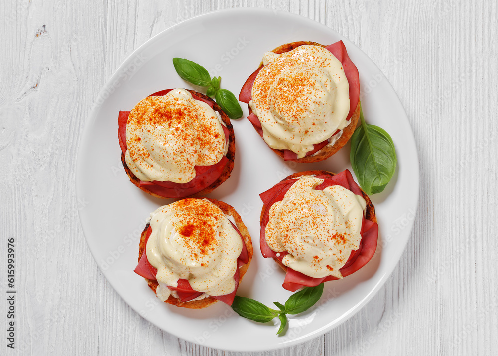 Eggs Benedict on white plate, top view