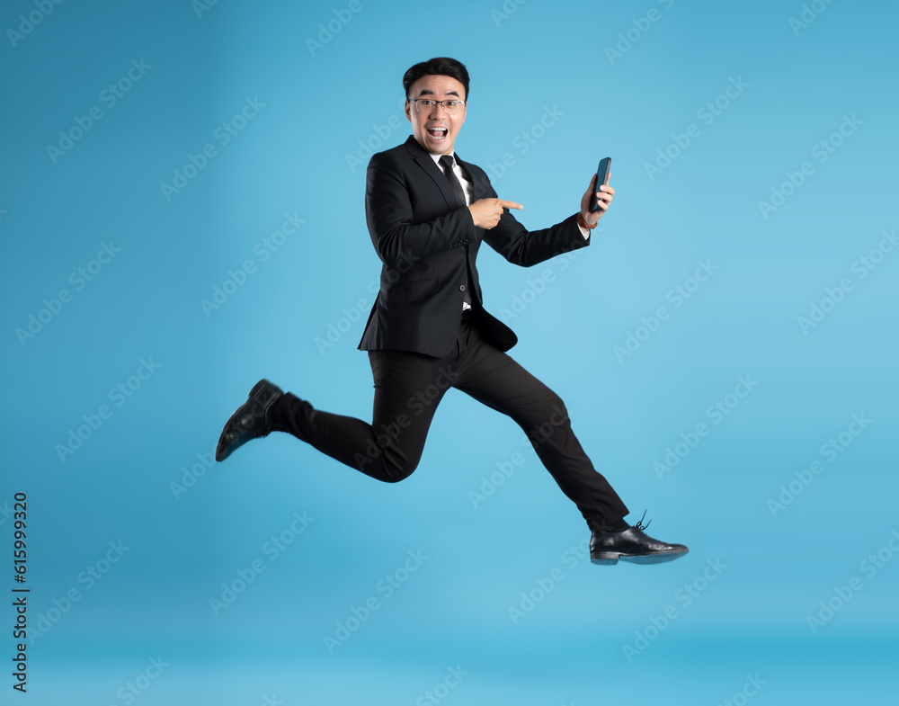 full body image of young businessman using phone on blue background