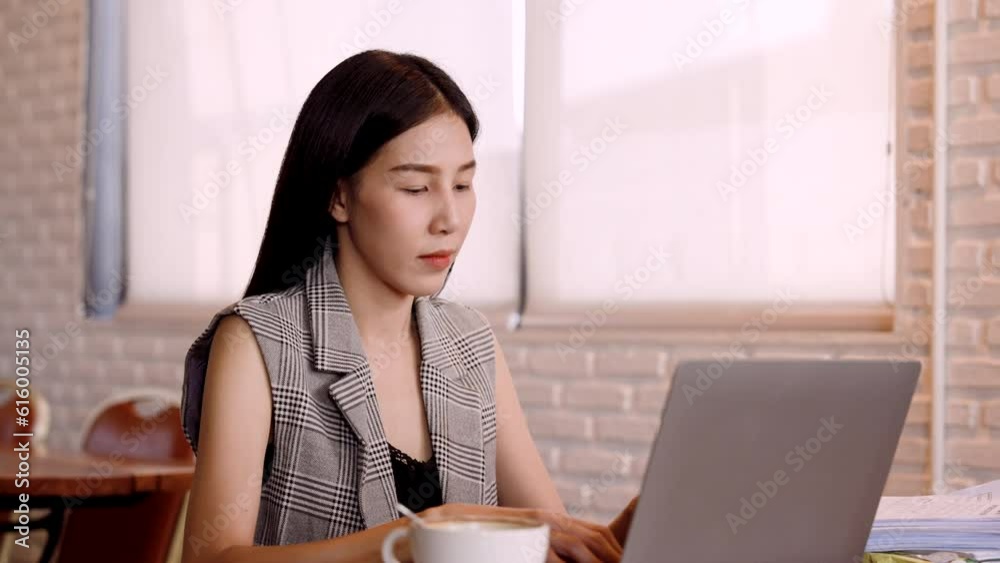 Close-up Asian woman typing on laptop computer, was busy, working, typing in hurry, before submission time for submission limit, works in cafe bakery for relaxation, with atmosphere restaurant. Close-up Asian woman typing on laptop computer, was busy, working, typing in hurry, before submission time for submission limit, works in cafe bakery for relaxation, with atmosphere restaurant.