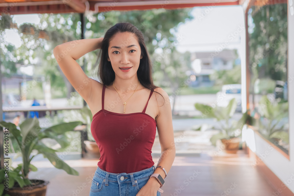 Portrait of asian beautiful sexy asian woman sitting smiling and relaxing Wearing a red strapless dress and jean skirt in a coffee shop